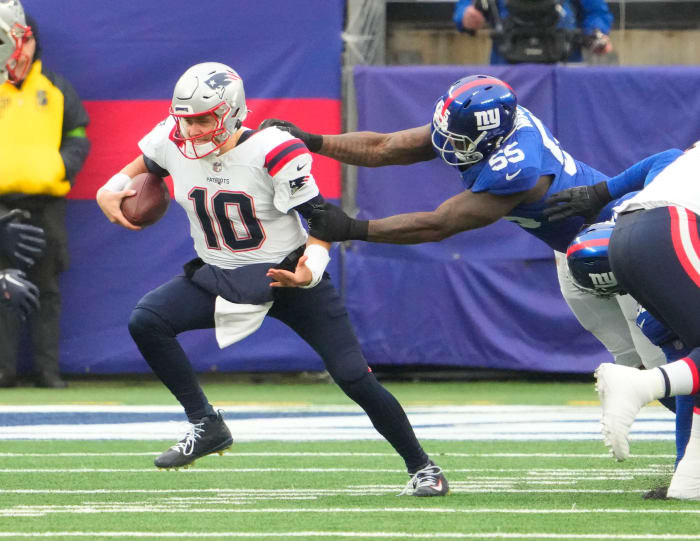 New York Giants linebacker Jihad Ward (55) has a hold on New England Patriots quarterback Mac Jones (10) in the 1st half at MetLife Stadium.